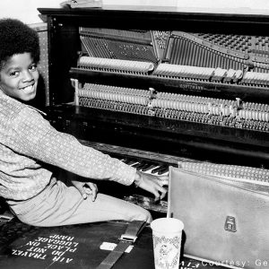 Michael Jackson plays around on a piano in the 1970s.